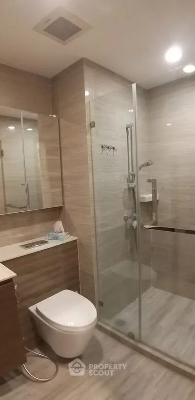 Modern bathroom with glass shower and sleek fixtures in a contemporary apartment.