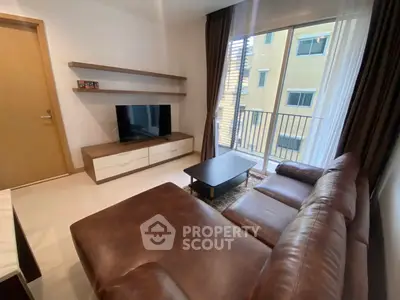 Modern living room with leather sofa and balcony view in a stylish apartment.