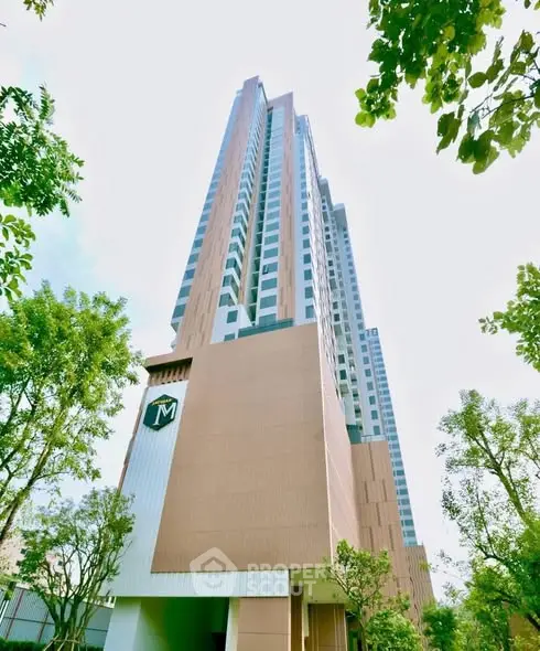 Stunning high-rise building with modern architecture and lush greenery, perfect for urban living.