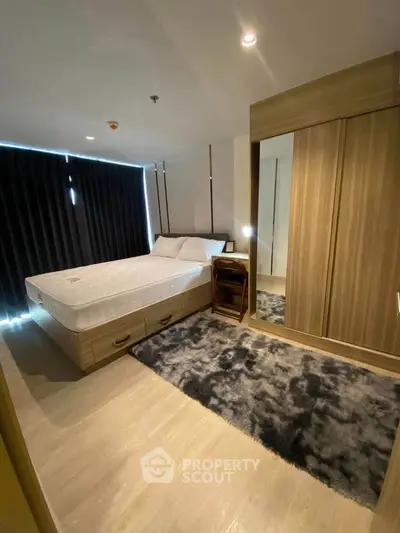 Modern bedroom with stylish wooden wardrobe and cozy bed in a well-lit apartment.