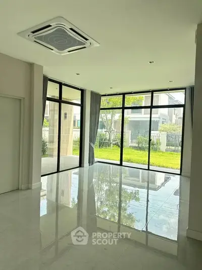 Spacious modern living room with large windows and garden view