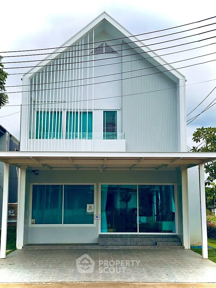 Modern two-story house with sleek design and large windows, featuring a covered driveway and minimalist facade.