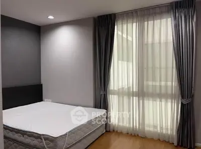Spacious bedroom with large window and elegant curtains in modern apartment