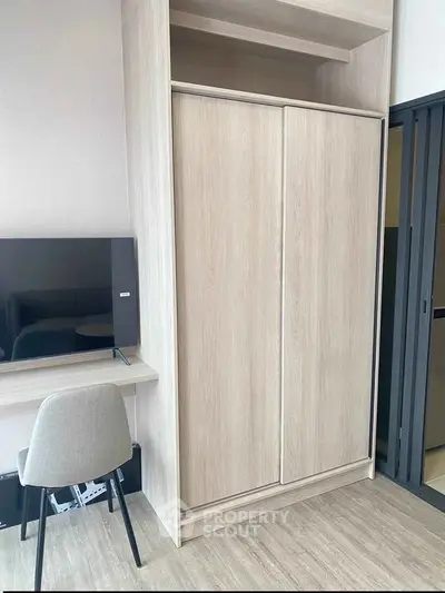 Modern study area with sleek wooden wardrobe and flat-screen TV