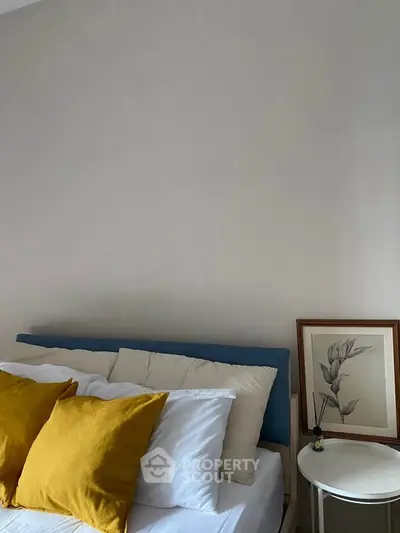 Cozy bedroom with stylish decor and vibrant yellow pillows.