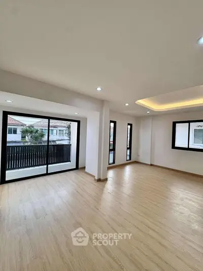 Spacious modern living room with large windows and wooden flooring