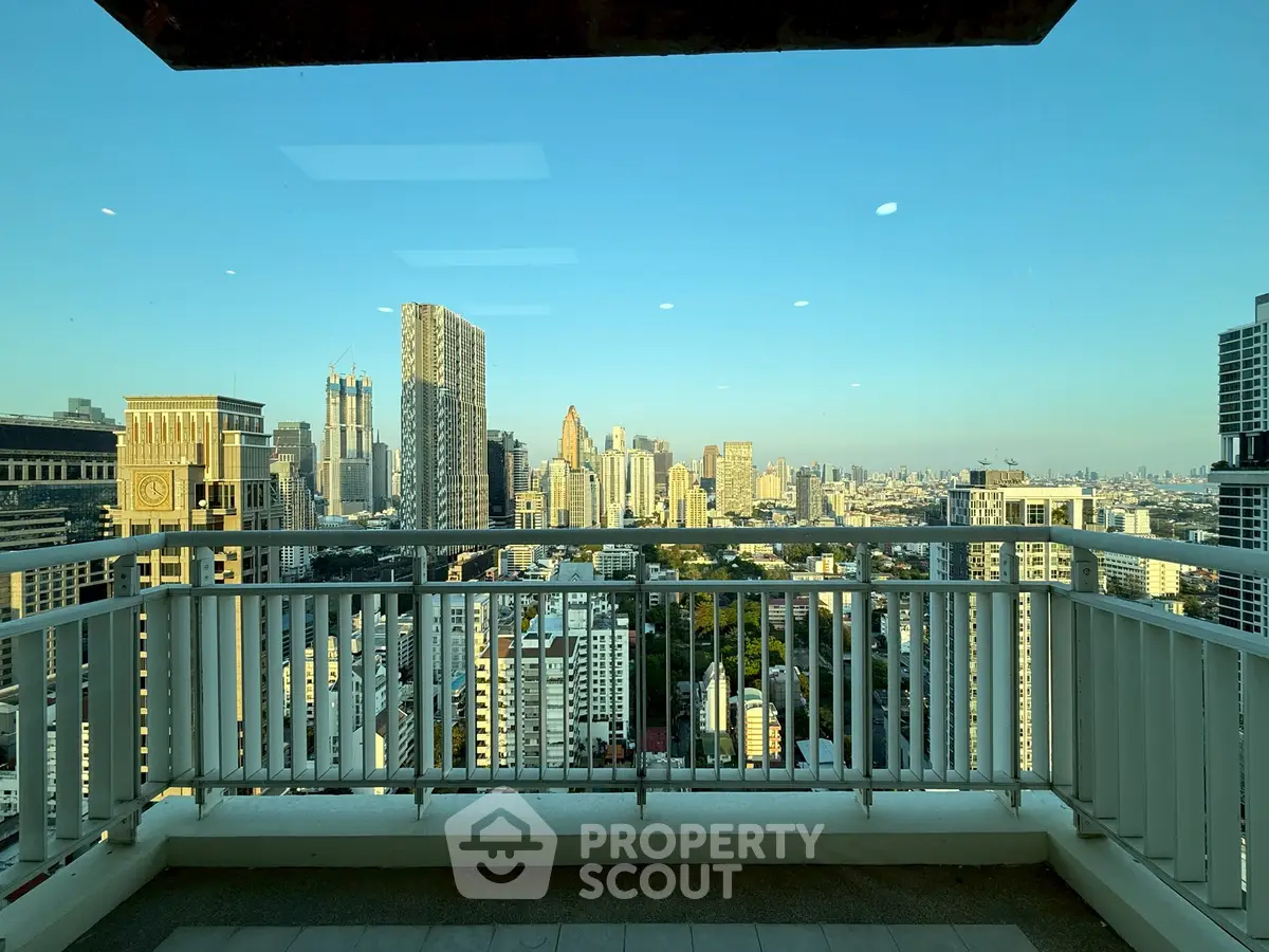 Stunning cityscape view from a high-rise balcony with modern railing.