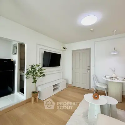 Modern living room with sleek design, featuring a wall-mounted TV, stylish furniture, and a cozy dining area.