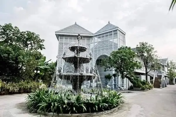 Stunning colonial-style mansion with elegant fountain and lush greenery, perfect for luxury living.