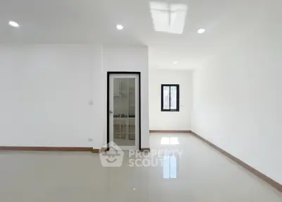 Spacious minimalist interior with glossy floors and natural light, perfect for modern living.