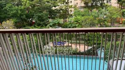 Stunning balcony view overlooking lush garden and inviting swimming pool in a serene residential area.