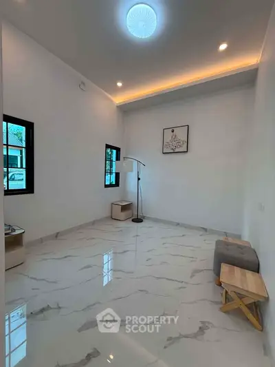 Spacious modern living room with elegant marble flooring and stylish lighting.