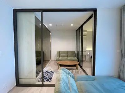 Modern living room with stylish green sofas and glass sliding doors