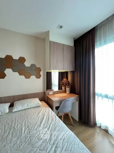 Modern bedroom with stylish decor and natural light, featuring a cozy bed and a functional study area.
