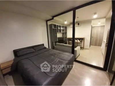 Modern bedroom with glass partition and sleek furnishings in a contemporary apartment.
