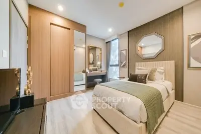Luxurious bedroom with modern decor and ample natural light, featuring a stylish bed and elegant furnishings.
