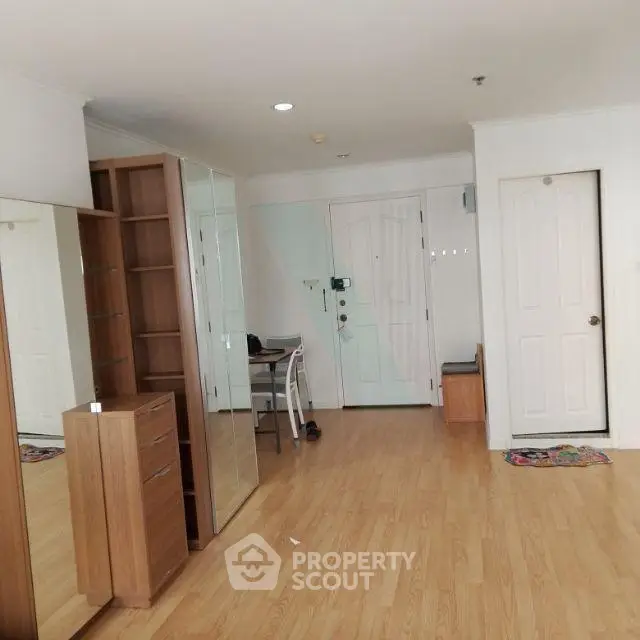 Spacious apartment interior with wooden flooring and modern furniture.