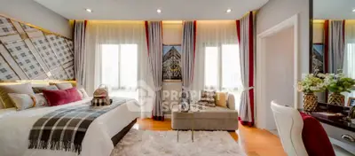 Luxurious bedroom with elegant decor and plush furnishings, featuring a stylish seating area and large windows.