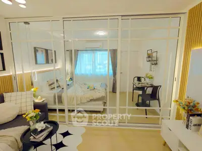 Modern open-plan living room with stylish decor and glass partition leading to cozy bedroom.