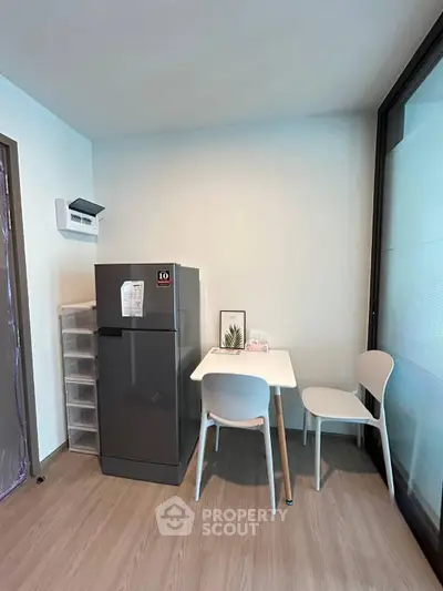 Cozy kitchen corner with fridge and dining table in modern apartment