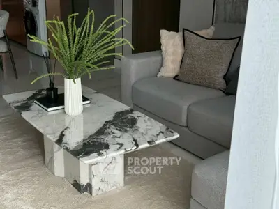 Stylish living room with modern marble coffee table and cozy gray sofa