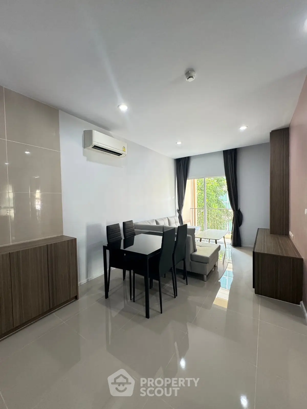 Modern living room with sleek furniture and natural light from balcony