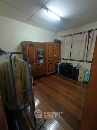 Cozy storage room with wooden flooring and ample cabinet space.
