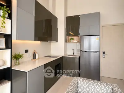 Modern kitchen with sleek cabinetry and stainless steel appliances in a stylish apartment.