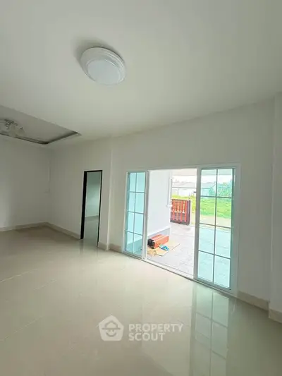 Spacious living room with large sliding glass doors opening to a patio, offering ample natural light.