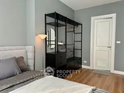 Modern bedroom with stylish open wardrobe and cozy bed in sleek apartment.