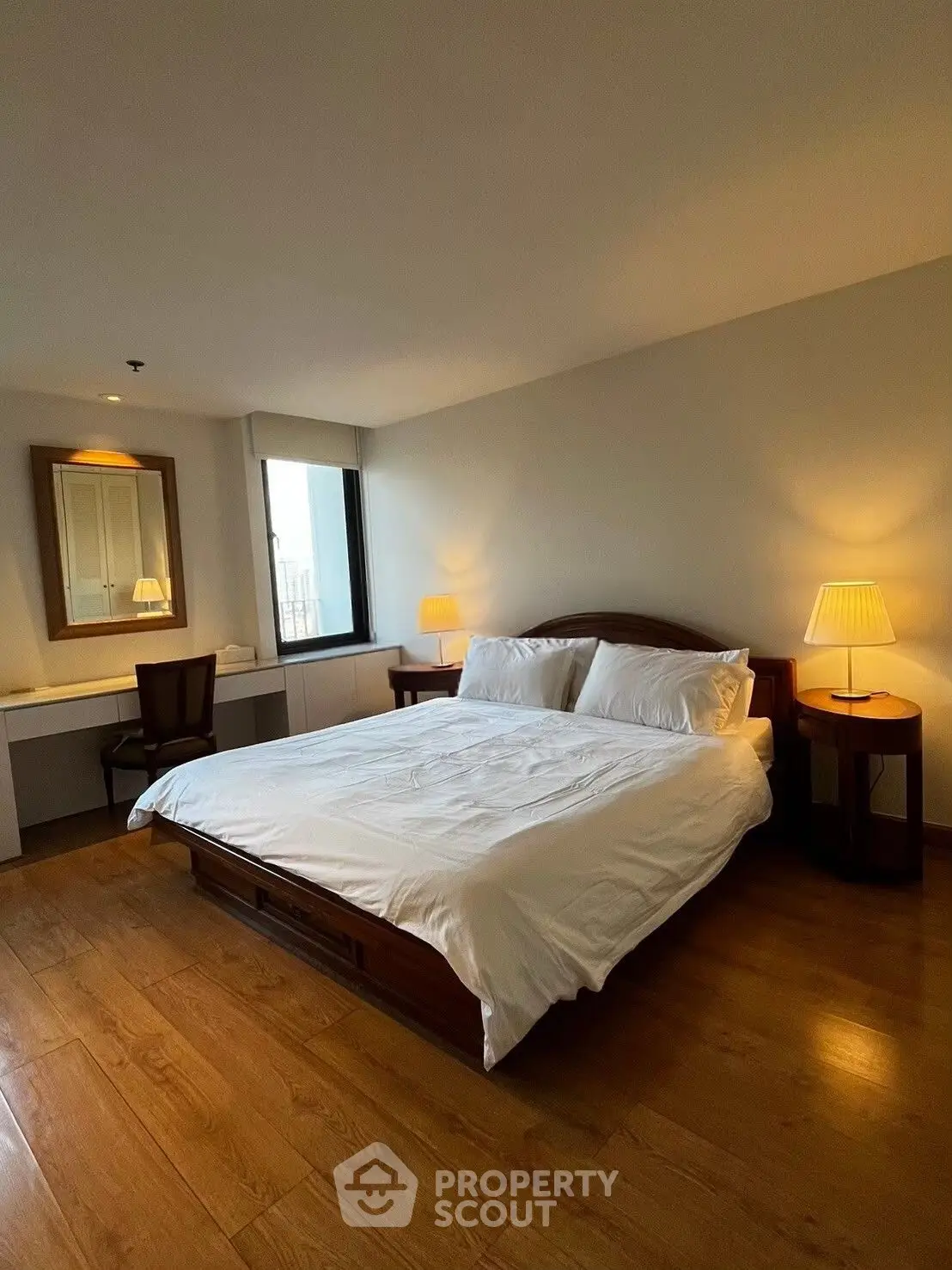 Spacious bedroom with wooden flooring and elegant decor