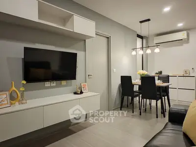 Modern living room with sleek furniture and dining area, featuring a wall-mounted TV and stylish lighting.