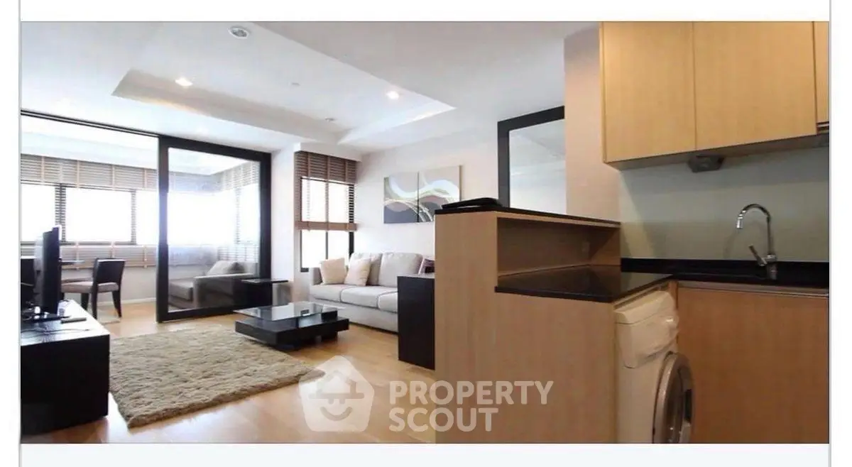 Modern living room with open layout and washing machine in stylish apartment.