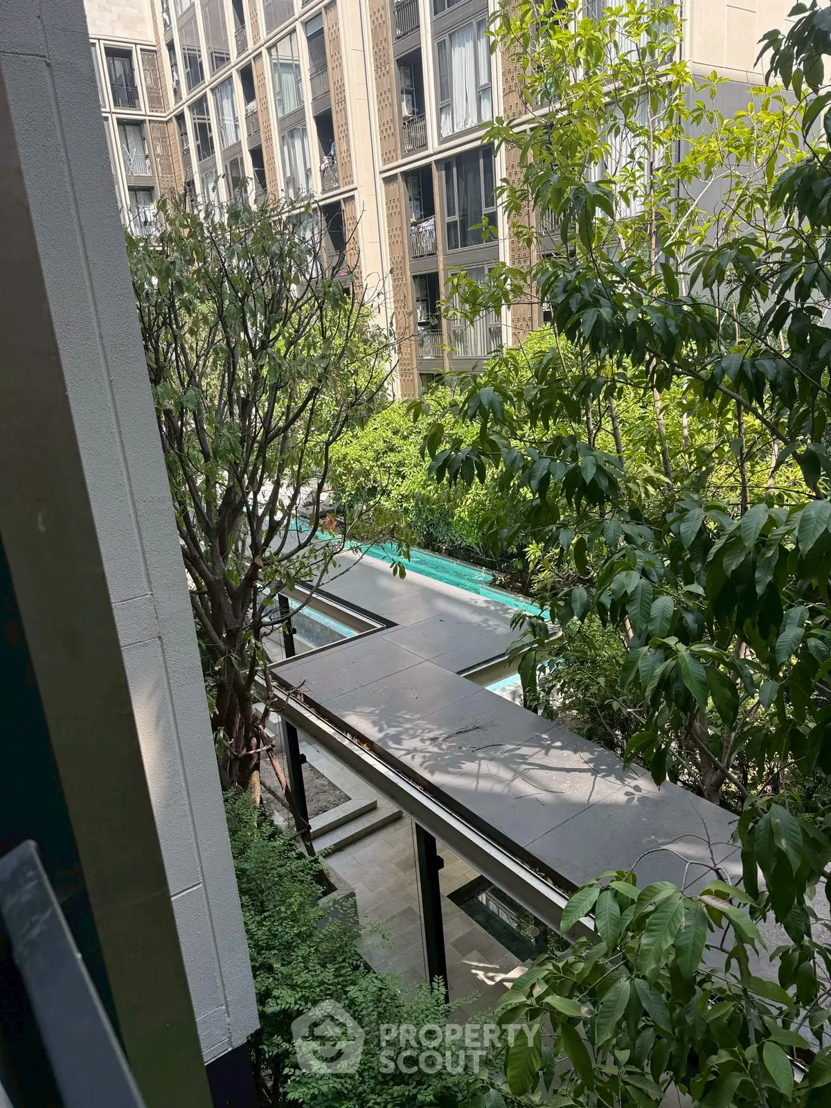 Modern apartment building with lush greenery and pool view