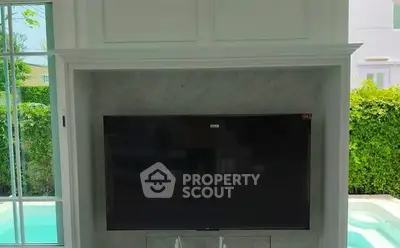 Luxurious living room with large TV and pool view, perfect for entertainment.