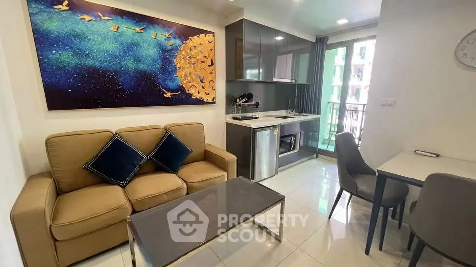Modern living room with stylish decor and compact kitchen in open layout apartment.