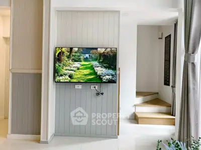 Modern interior with wall-mounted TV and elegant staircase in a stylish home.
