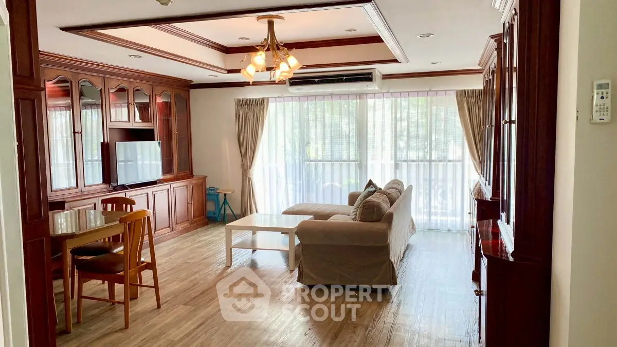 Spacious living room with elegant wooden furniture and large windows for natural light.
