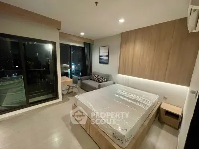 Modern bedroom with large windows and city view, featuring a cozy bed and stylish decor.
