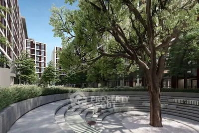 Modern residential complex with lush greenery and outdoor seating area.