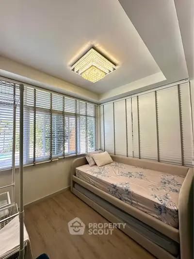 Cozy bedroom with elegant lighting and large windows for natural light