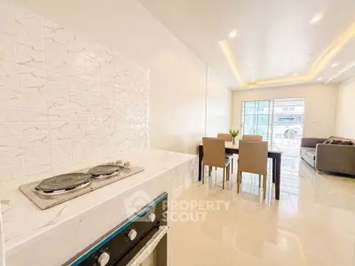 Modern open-layout kitchen and living room with elegant dining area and cozy seating.
