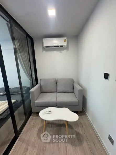 Cozy modern living room with gray sofa and air conditioning, perfect for relaxation.