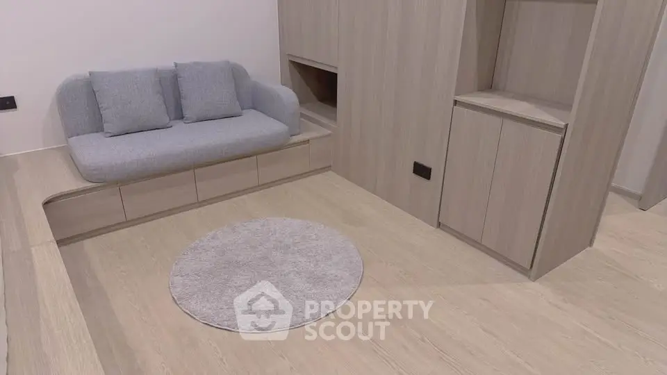 Modern minimalist living room with light wood flooring and built-in storage