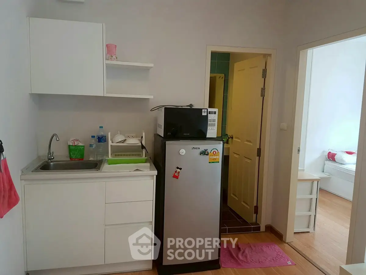 Compact kitchen with fridge and sink in modern apartment