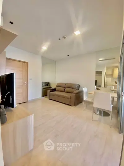 Modern living room with sleek furniture and wooden flooring in a stylish apartment.