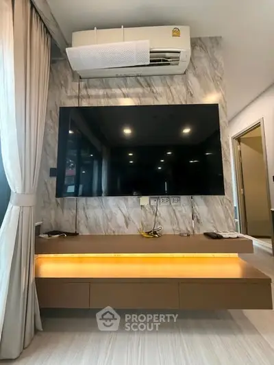 Modern living room with wall-mounted TV and sleek air conditioning unit.