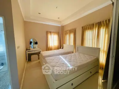Cozy bedroom with twin beds, elegant vanity, and soft natural lighting.