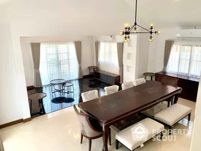 Spacious dining room with elegant chandelier and large windows for natural light