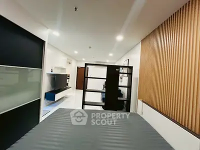 Modern studio apartment with sleek design and open layout, featuring a stylish partition and contemporary decor.